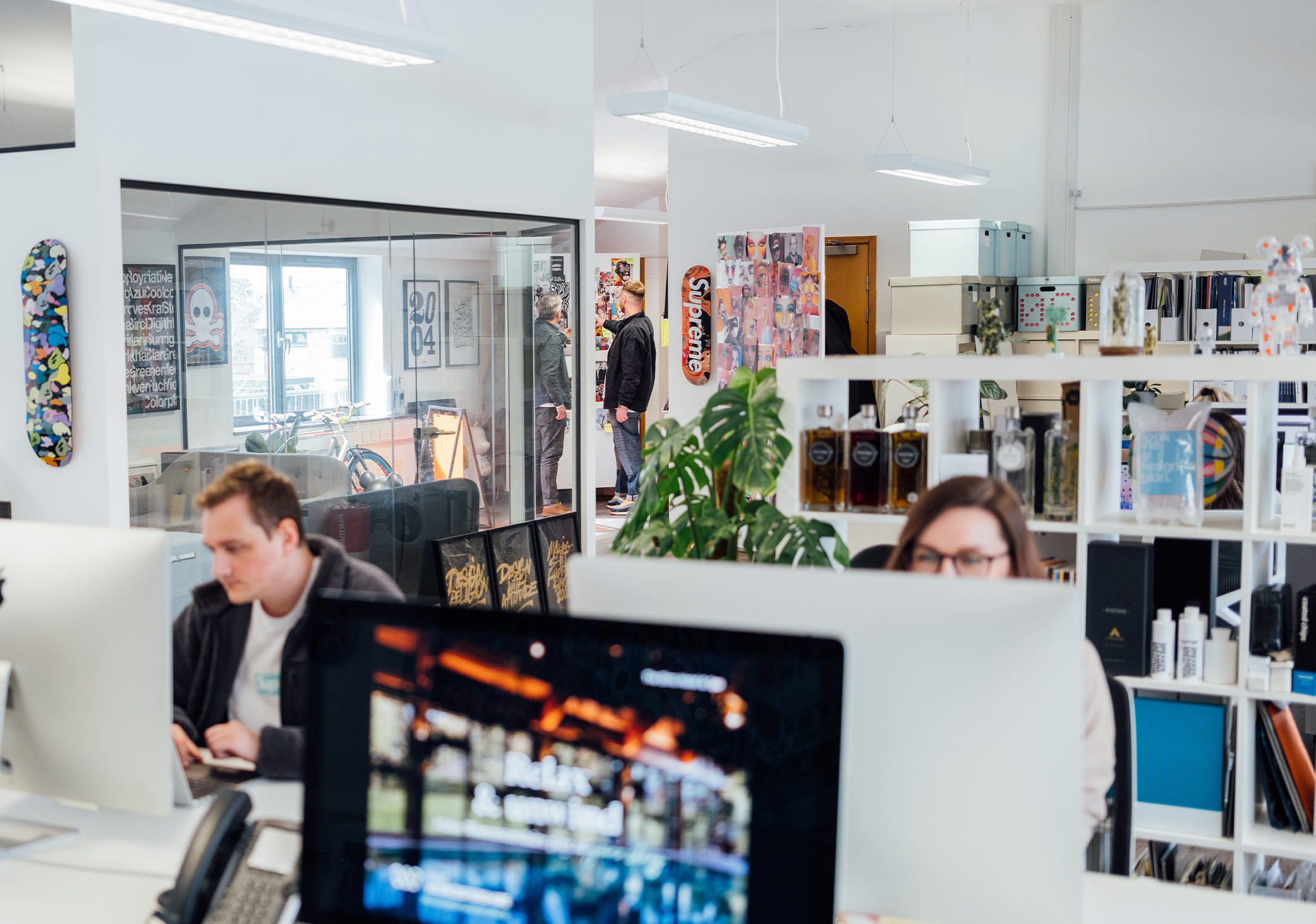 Inside DesignReligion design agency with people working and looking at moodboards in background